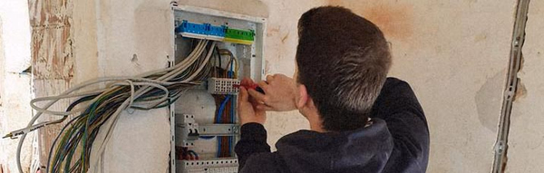 Auszubildender von Roxer Elektrotechnik arbeitet an einem Sicherungskasten im Rohbau